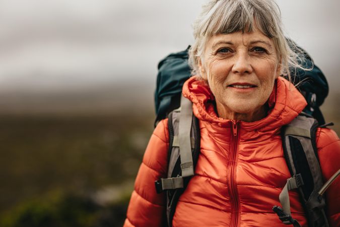 Portrait of woman standing outdoors on hiking trip