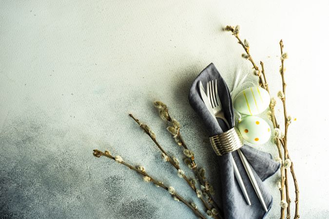 Top view of Easter holiday concept with pussy willow surrounding napkin with decorative eggs