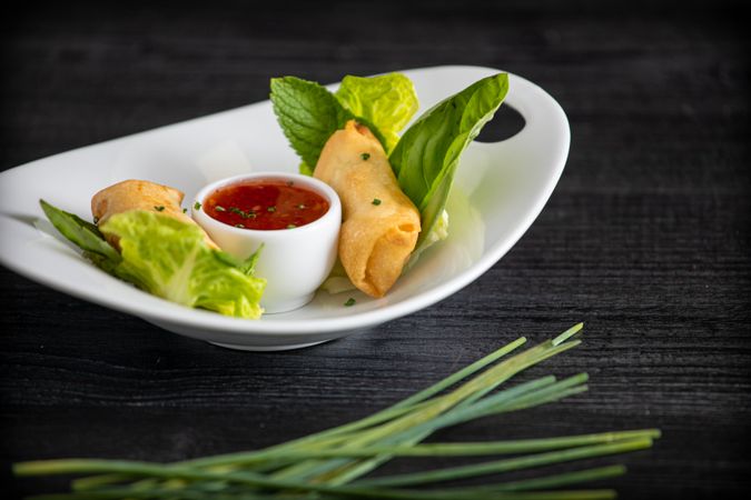 Vietnamese rolls with sweet chili on glass plate