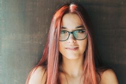 Woman in glasses leaning on wall