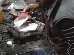 Crop craftsman pouring material in metal form