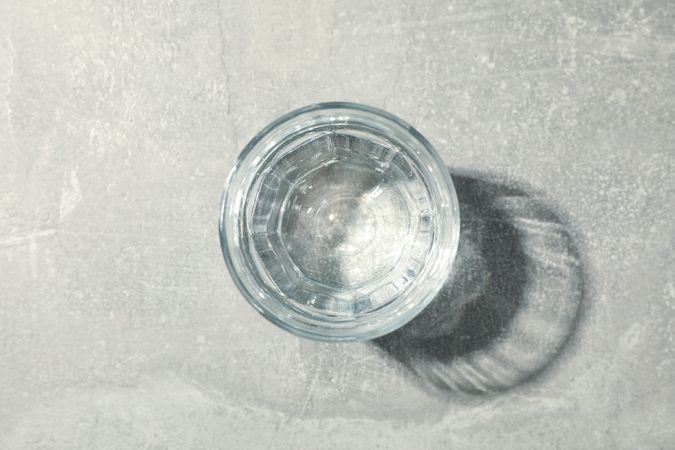 Full glass of water on marble table, top view