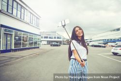Woman posing outside with selfie stick on overcast day 5QWmdb