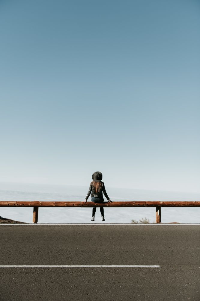 Woman on fence on hill