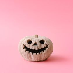Pumpkin skull on pastel pink wall