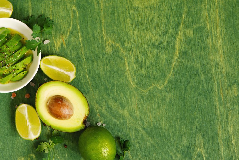 Green table with fresh juice ingredients and copy space