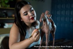 Close Up of woman working on clay horse sculpture 4d8BN4