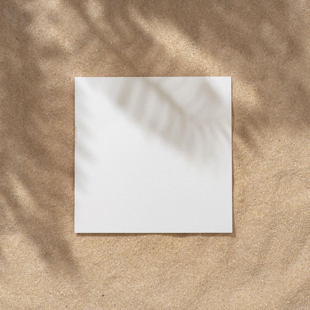 Sand with palm leaf shadows and central square