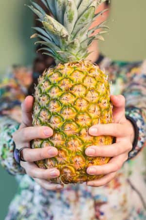 Woman holding pineapple between her hands