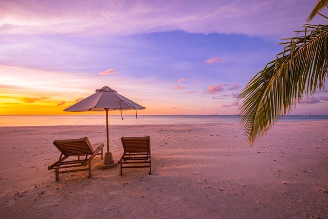 Dusk on a beach with reclining chairs on tropical deserted beach