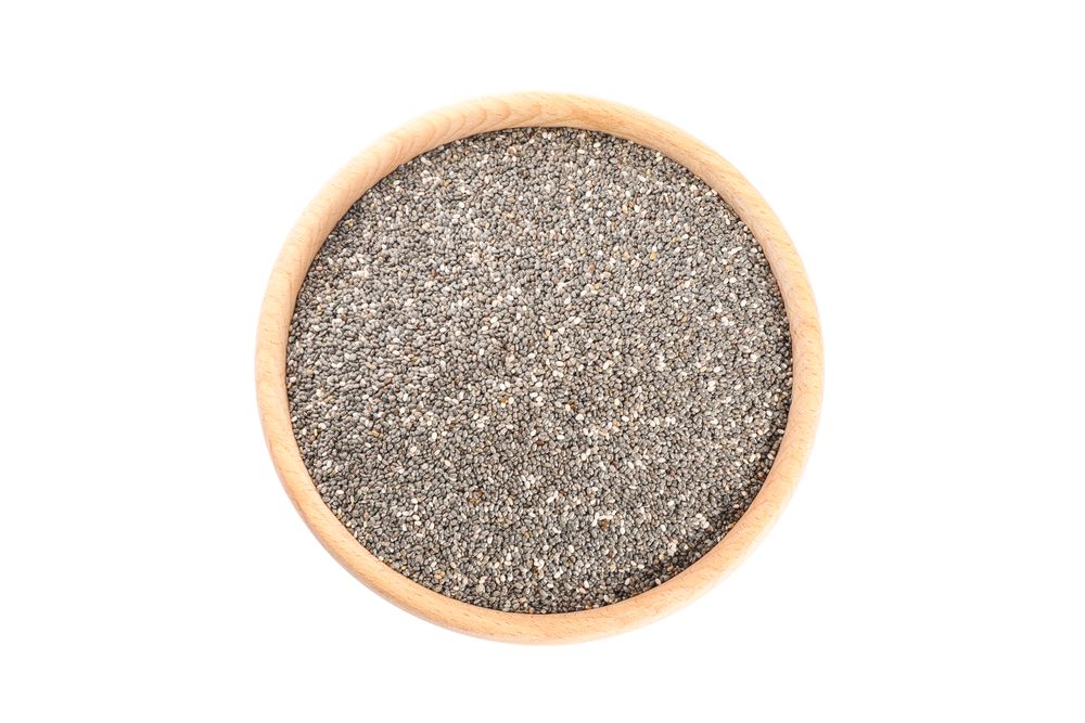 Chia seeds in wooden bowl isolated on studio background