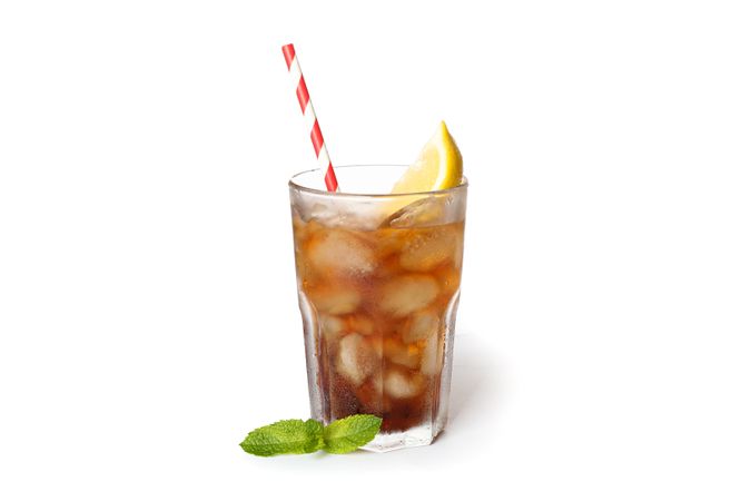 Glass of cold cola with lemon isolated on blank background
