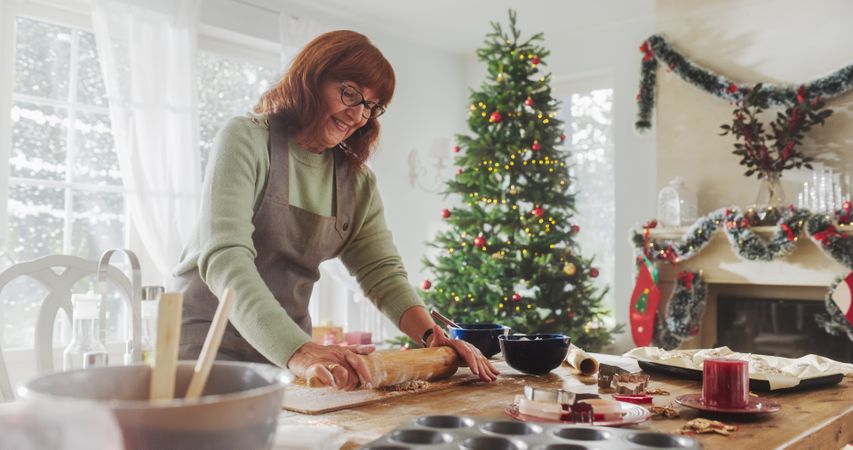 Portrait of Mature Female Preparing Dough for Making Gingerbread for Christmas at Home.