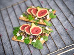 Fresh figs and green leaves on wooden board
