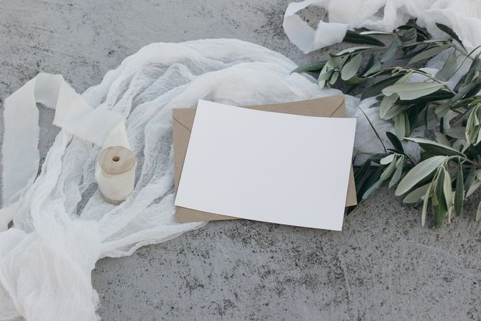 Greeting card or invitation mockup with silk ribbon and olive branches