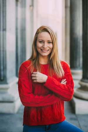 Stylish female standing near marble columns