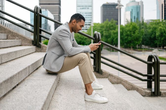 Man sitting on stairs using smartphone