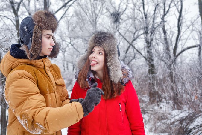 Teenage couple having funny conversation in wintery forest