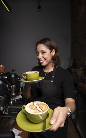Hispanic woman with cappuccino cups