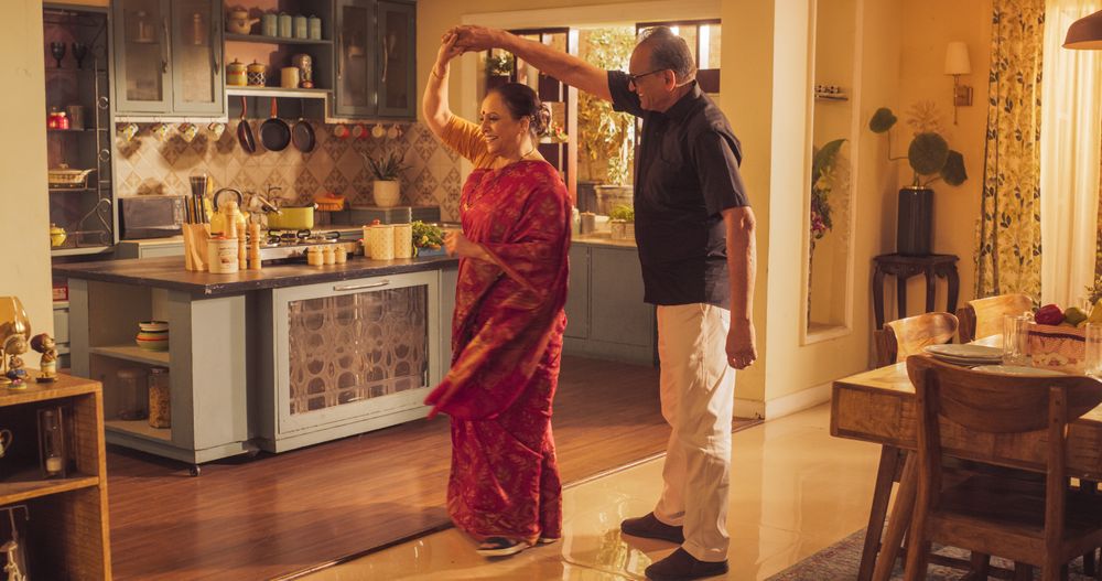 Portrait of Happy Indian Couple Posing in Embrace while Standing in the Kitchen