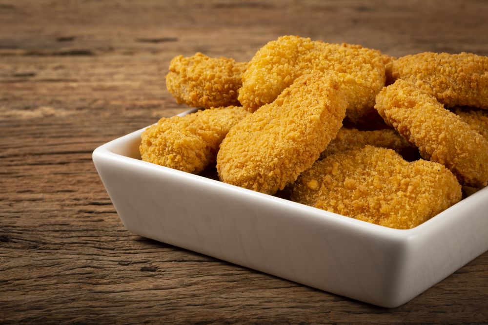 Fried chicken nuggets with ketchp and rose sauce.