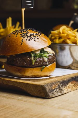 Juicy delicious burger and fried potato on table