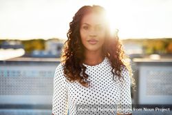 Radiant Black woman on sunny roof and dotted shirt 5RkY14