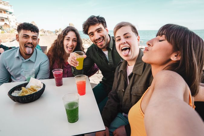 Friends Toasting Drinks at Seaside Gathering