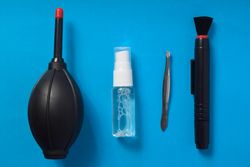 Top view of lens cleaning kit on blue background