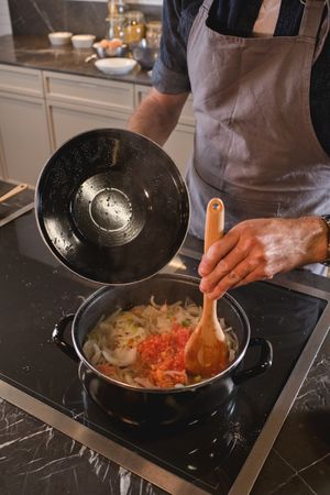 Unrecognizable male chef cooking dinner at home