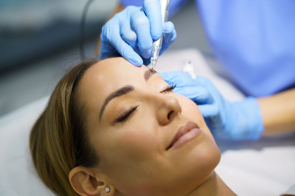 Woman having permanent make-up applied to eyebrows