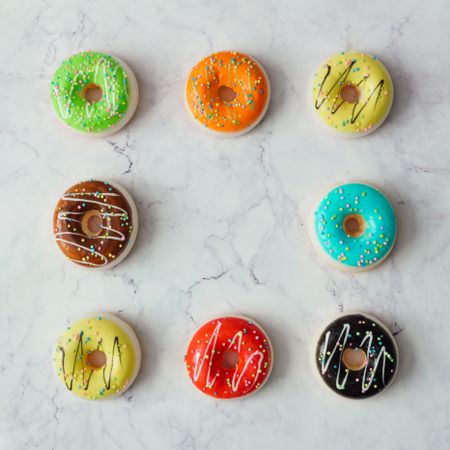 Square of colorful donuts on marble background