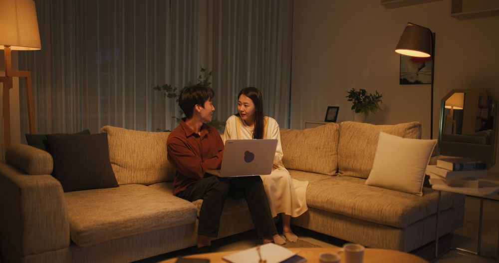 Young and Lovely South Korean Couple Using Laptop Computer in the Evening