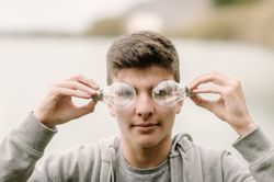 Young teenager with light bulbs on eyes