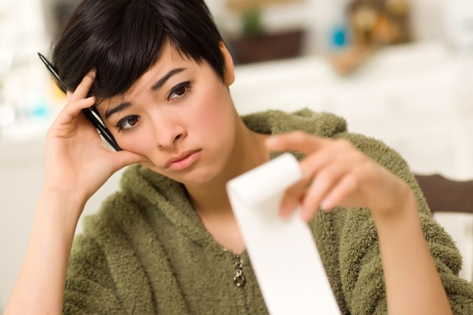 Young Woman Agonizing Over Financial Calculations