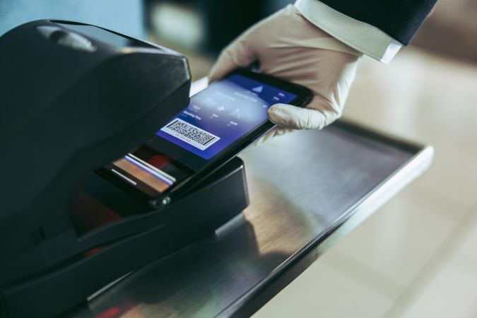 Scanning of boarding pass on mobile phone at airport counter