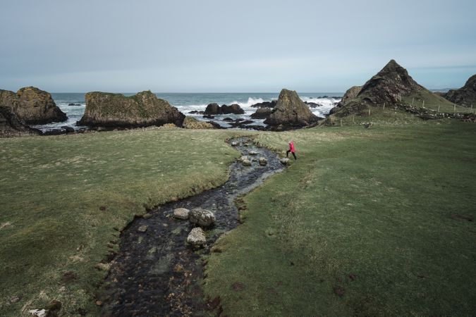 Woman walking along mountain river estuary