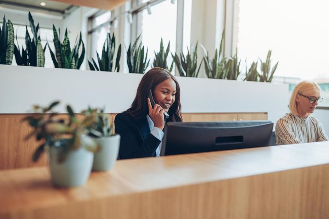 Two woman working behind the front desk