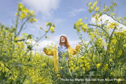 Happy red haired woman smiling in a rapeseed field 5oekGb