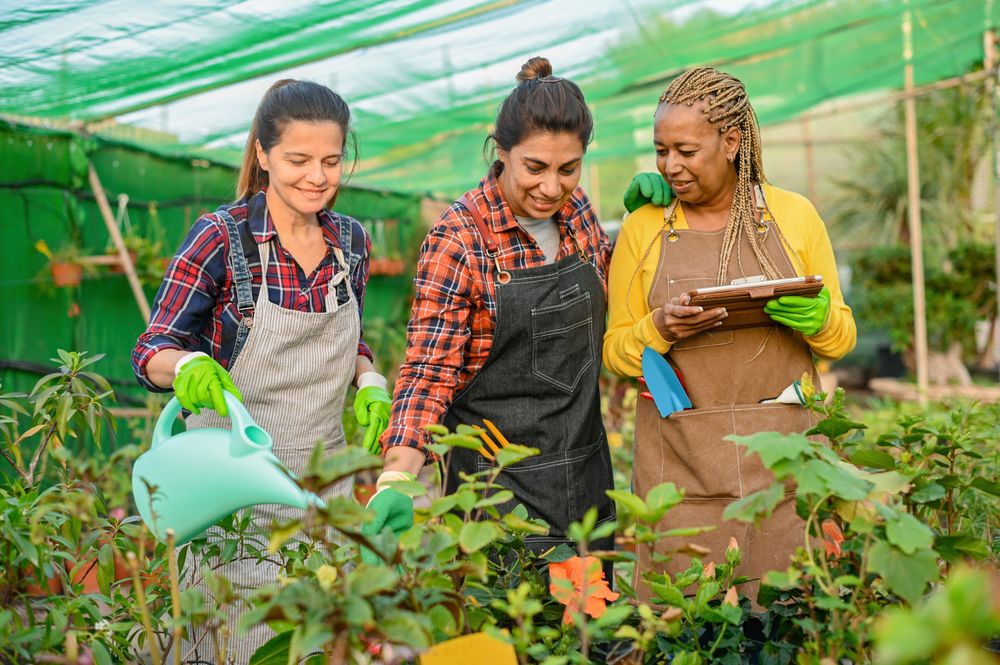 Smiling multiracial women working with plants