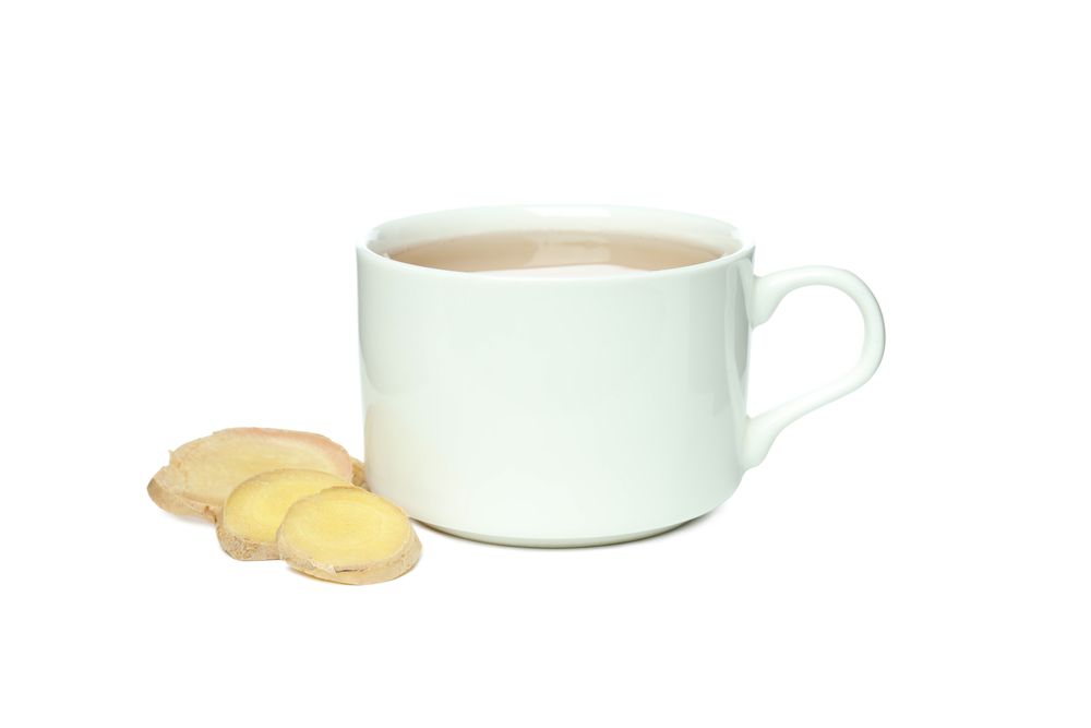 Cup of tea and ginger slices, isolated on plain background