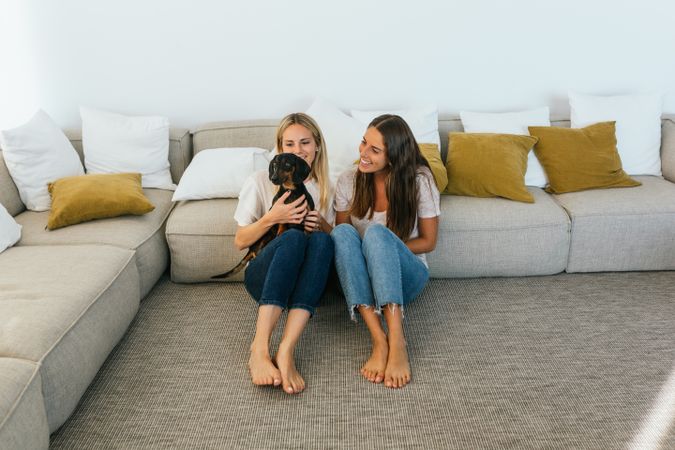 Smiling girlfriends with cute dog