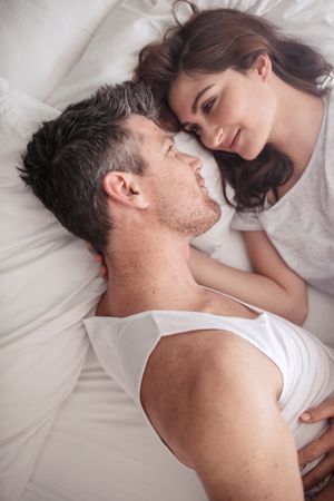 Overhead close up shot of romantic couple lying in bed