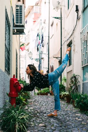 Casual woman dancing on old city street