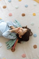 Little girl with angelic wings lying with back on floor