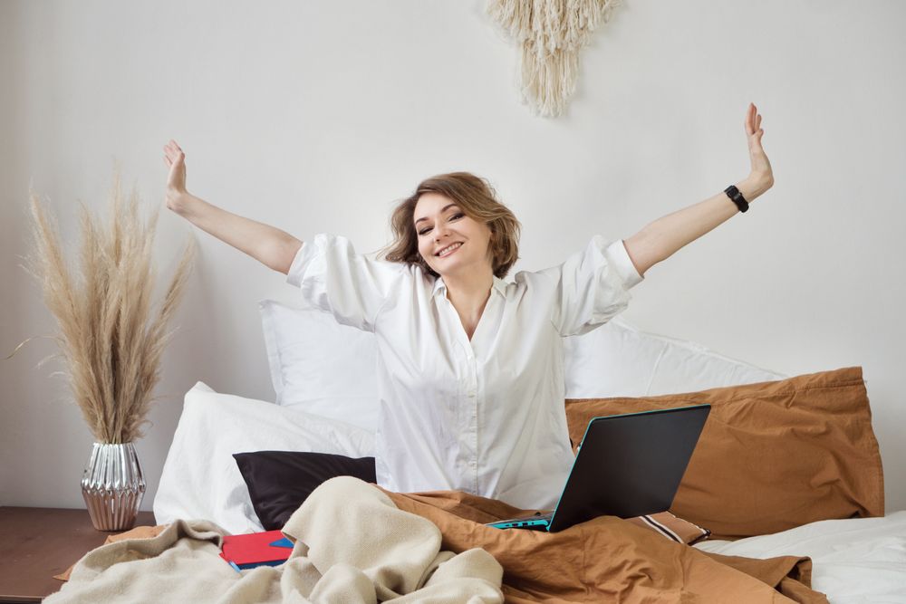 Joyful Woman In Blouse Sitting At Comfortable Bed
