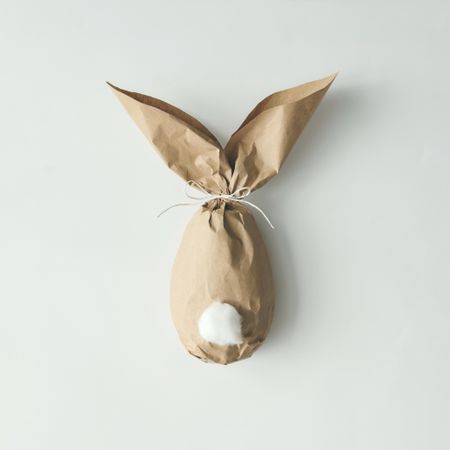 Egg wrapped in brown paper in Easter bunny shape