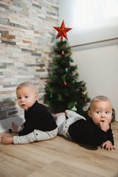 Happy babies near Christmas tree and gifts