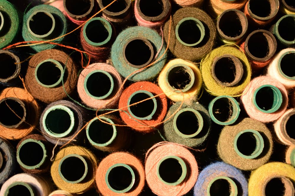 Many colorful spools of string for sewing machine