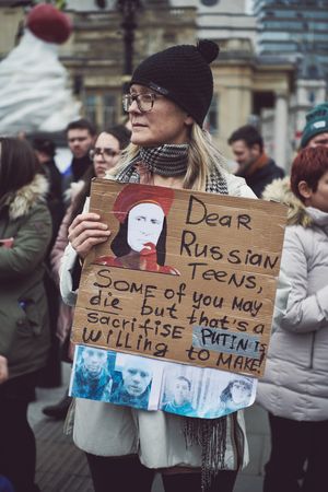 London, England, United Kingdom - March 5 2022: Woman in hat and glasses with anti-Putin sign